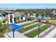 Aerial view of bocce ball courts and a clubhouse by a pool, creating a luxurious recreational space at 12140 Wellen Golf St # 106, Venice, FL 34293