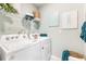 Convenient laundry room with a washer, dryer, and storage shelves, ready for efficient chores at 12141 Karney Ave, Port Charlotte, FL 33981