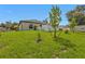 Spacious backyard with lush green grass, a privacy fence, and small trees at 1353 Newton St, Port Charlotte, FL 33952