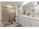 Bright bathroom featuring a walk-in shower and double sink vanity with white cabinets at 1353 Newton St, Port Charlotte, FL 33952