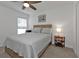 Inviting bedroom features a ceiling fan, wood-frame bed with a cozy quilt, and a classic bedside table at 1353 Newton St, Port Charlotte, FL 33952