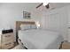 Cozy bedroom with a wooden headboard, soft gray bedding, ceiling fan, and a quaint framed painting at 1353 Newton St, Port Charlotte, FL 33952