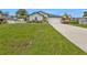 Landscaped home featuring an attached garage and driveway leading to the front of the house at 1353 Newton St, Port Charlotte, FL 33952