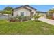 Charming home featuring an attached garage and a manicured lawn with tropical landscaping at 1353 Newton St, Port Charlotte, FL 33952