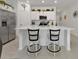 Well-lit kitchen with a large island, stainless steel appliances, white cabinetry, and bar stool seating at 1353 Newton St, Port Charlotte, FL 33952