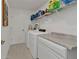 Well-lit laundry room features white appliances, storage shelves and extra counter space at 1353 Newton St, Port Charlotte, FL 33952