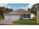 Charming single-story home featuring a three-car garage, neutral color palette, and well-manicured lawn at 1478 Mableton Dr, Port Charlotte, FL 33953