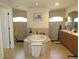 Luxurious bathroom features a large soaking tub, separate vanities, and natural light from arched windows at 1500 Westover St, Port Charlotte, FL 33953