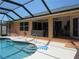 A beautiful outdoor patio with a screened-in pool, cozy seating area, and modern outdoor heater at 1500 Westover St, Port Charlotte, FL 33953