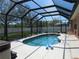 The screened in pool, surrounded by lush greenery, features clean tile and ample deck space for entertaining at 1500 Westover St, Port Charlotte, FL 33953