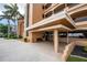 Condo complex main entrance featuring covered entry, tile flooring, and nearby mature palm trees at 1601 Park Beach Cir # 114/4, Punta Gorda, FL 33950