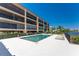 Exterior shot of the community pool with lounge chairs, a white tile deck, and beautiful views at 1601 Park Beach Cir # 114/4, Punta Gorda, FL 33950