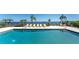 Community swimming pool, surrounded by lounge chairs and views of the adjacent bay at 1601 Park Beach Cir # 114/4, Punta Gorda, FL 33950