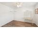 Bright bedroom with hardwood floors, ceiling fan, and decorative shelving unit at 175 Kings Hwy # 717, Punta Gorda, FL 33983