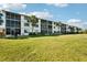 Long view of the condo building featuring lush green lawns and beautifully landscaped grounds at 175 Kings Hwy # 717, Punta Gorda, FL 33983