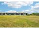 View of a well-maintained condo building set against a backdrop of lush green landscape at 175 Kings Hwy # 717, Punta Gorda, FL 33983