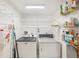 Bright laundry room featuring a washer, dryer, shelving, and ample storage space at 175 Kings Hwy # 717, Punta Gorda, FL 33983