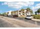 Scenic view of a condo building with ample parking and palm trees at 175 Kings Hwy # 717, Punta Gorda, FL 33983