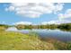 Scenic view of the community pond, surrounded by lush greenery under a bright sky at 175 Kings Hwy # 717, Punta Gorda, FL 33983