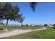 Scenic golf course view featuring a winding path, lush green grass, and distant neighborhood homes at 1840 Knights Bridge Trl, Port Charlotte, FL 33980