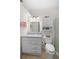 Bathroom with a granite countertop vanity, white cabinets, decorative mirror, and toilet at 196 The Corso # 196, Venice, FL 34285