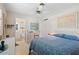 Bright bedroom with ceiling fan offering access to the bathroom featuring white cabinets at 196 The Corso # 196, Venice, FL 34285