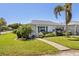 Well-maintained single-story home featuring a lush green lawn, vibrant landscaping, and inviting curb appeal at 196 The Corso # 196, Venice, FL 34285