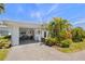 Home exterior with covered parking, tropical landscaping and charming curb appeal at 196 The Corso # 196, Venice, FL 34285
