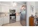 Bright kitchen featuring stainless steel appliances, white cabinetry, and modern backsplash at 196 The Corso # 196, Venice, FL 34285