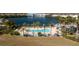 Aerial view of the neighborhood pool and clubhouse near a tranquil lake with beautiful landscaping and palm trees at 2001 Bal Harbor Blvd # 2202, Punta Gorda, FL 33950