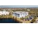Aerial view of condo building near lake, featuring ample parking and lush greenery, with neighborhood in background at 2001 Bal Harbor Blvd # 2202, Punta Gorda, FL 33950