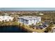 An aerial view showcases a low-rise condominium complex surrounded by lush landscaping and overlooking a serene lake at 2001 Bal Harbor Blvd # 2202, Punta Gorda, FL 33950
