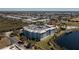 Aerial view of a condo building surrounded by palm trees, lush landscaping, and views of the neighborhood and nearby lake at 2001 Bal Harbor Blvd # 2202, Punta Gorda, FL 33950