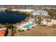 Aerial view showcasing a community pool and clubhouse on the lake with lush landscaping and palm trees at 2001 Bal Harbor Blvd # 2202, Punta Gorda, FL 33950