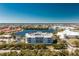 Aerial view of a modern condo building surrounded by palm trees and lush landscape near a serene lake and neighborhood at 2001 Bal Harbor Blvd # 2202, Punta Gorda, FL 33950