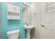 Bathroom with toilet and pedestal sink against a turquoise wall at 2001 Bal Harbor Blvd # 2202, Punta Gorda, FL 33950