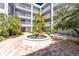 Charming courtyard with a fountain, benches, lush greenery, landscaping and white facade buildings at 2001 Bal Harbor Blvd # 2202, Punta Gorda, FL 33950