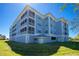 A beautiful blue condominium building is set among bright green grass and sunny blue skies at 2001 Bal Harbor Blvd # 2202, Punta Gorda, FL 33950
