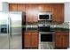 Kitchen featuring stainless appliances, granite countertops, tiled backsplash and wood cabinets at 2001 Bal Harbor Blvd # 2202, Punta Gorda, FL 33950