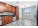 Charming kitchen with wood cabinetry, stainless steel appliances and gray wood look floors at 2001 Bal Harbor Blvd # 2202, Punta Gorda, FL 33950