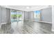 Spacious living room with wood-look floors, a ceiling fan, and sliding glass doors to a balcony at 2001 Bal Harbor Blvd # 2202, Punta Gorda, FL 33950
