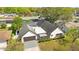 Aerial view of the home featuring lush landscaping, screened pool area, and driveway at 2027 59Th N St, Clearwater, FL 33760