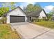 View of the home's driveway and two-car garage, accented with beautiful landscaping at 2027 59Th N St, Clearwater, FL 33760