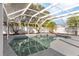 Screened in ground pool with rock waterfall feature and concrete pool deck offers a private backyard oasis at 2027 59Th N St, Clearwater, FL 33760