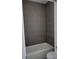 This bathroom features a bathtub and gray tiled wall at 23458 Macbeth Ct, Punta Gorda, FL 33980