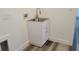 Clean laundry area featuring a new sink and cabinet with stylish flooring at 23458 Macbeth Ct, Punta Gorda, FL 33980