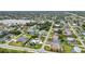 High aerial shot features a diverse neighborhood with a scenic lake backdrop, various homes, and tree-lined streets at 23531 Dunstan Ave, Port Charlotte, FL 33954