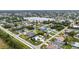 A wide aerial view shows a residential neighborhood with a lake, many houses, and green spaces at 23531 Dunstan Ave, Port Charlotte, FL 33954