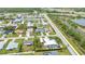 An aerial scene of a quiet residential neighborhood with houses, green spaces, and a serene pond nearby at 23531 Dunstan Ave, Port Charlotte, FL 33954