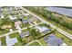 Overhead shot capturing a neighborhood's layout with pools, green lawns, and a glimpse of a tranquil pond at 23531 Dunstan Ave, Port Charlotte, FL 33954